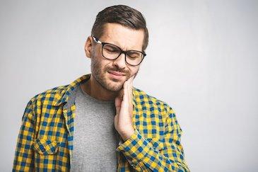 Man holding his jaw in pain, fort collins co