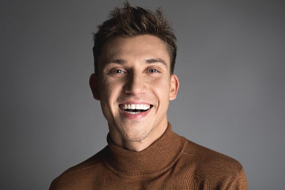 Younger man with brown hair smiling after wisdom teeth removal, fort collins co