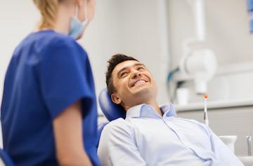 man smiling in dentist office before a tooth extraction in fort collins