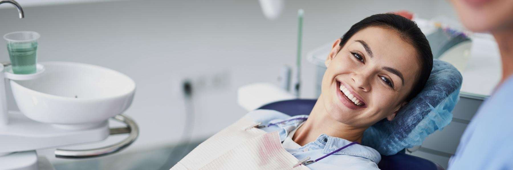 Younger woman smiling in dentist chair, fort collins co