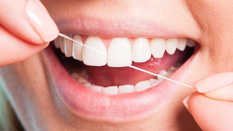 A person flossing | dentist in fort collins