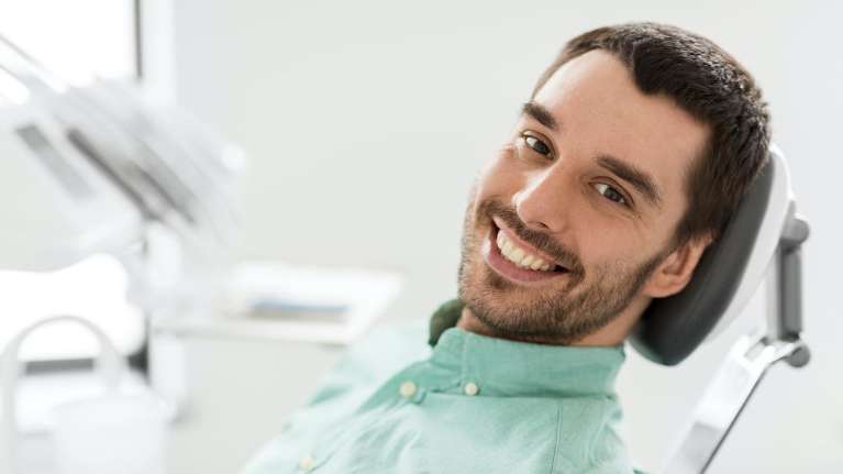 man smiling after dental services
