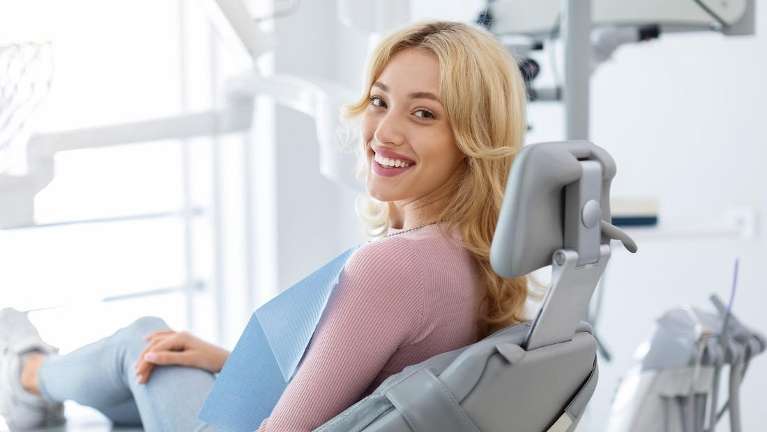 Blonde woman smiling in a dentist chair, fort collins co