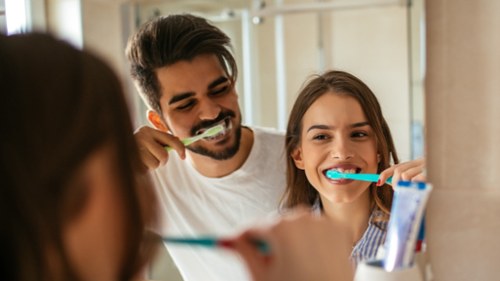 Man and woman smiling brushing their teeth, fort collins colorado
