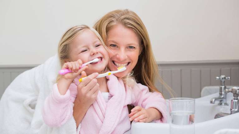 A mother and daughter brushing their teeth | hygienist Fort Collins