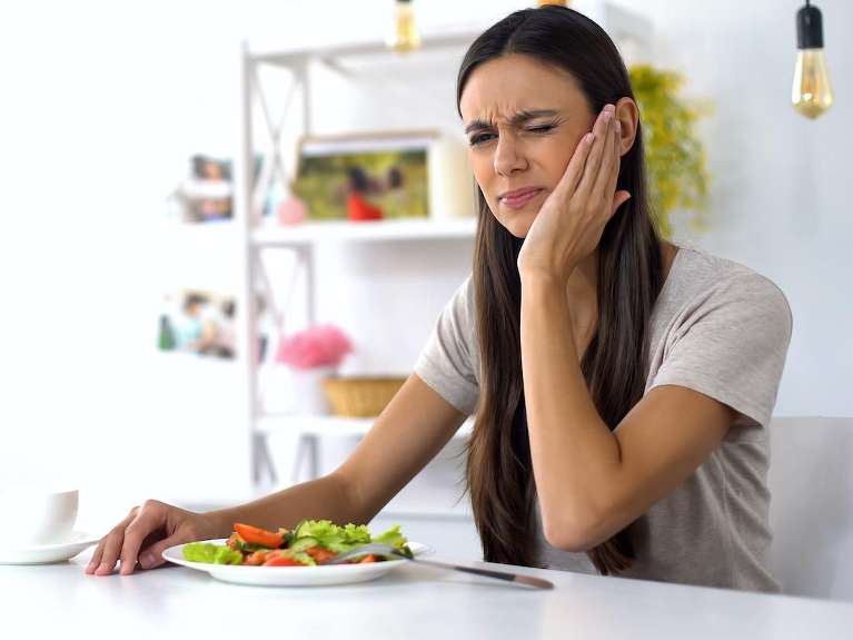 Woman holding her jaw in pain, fort collins co