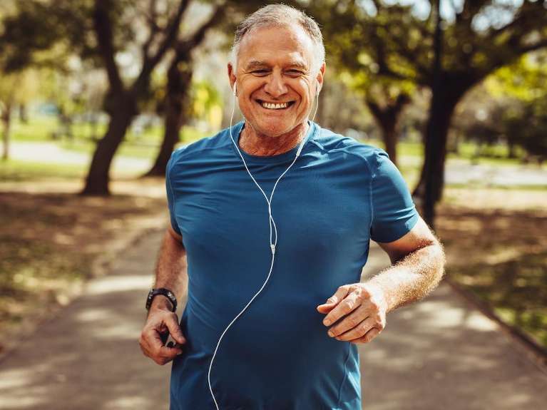 Old man running and smiling with headphones in, fort collins co 