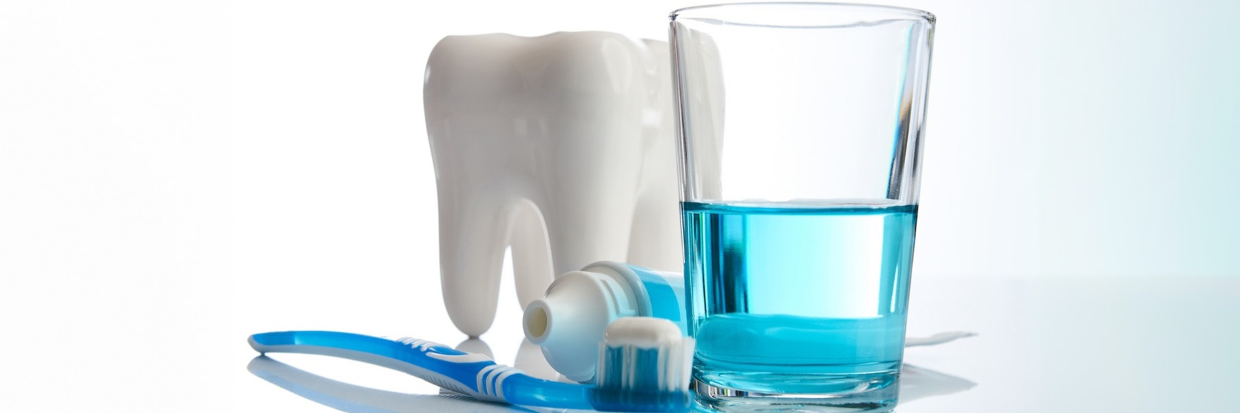 Toothbrush and toothpaste next to a glass with mouthwash in it, fort collins colorado