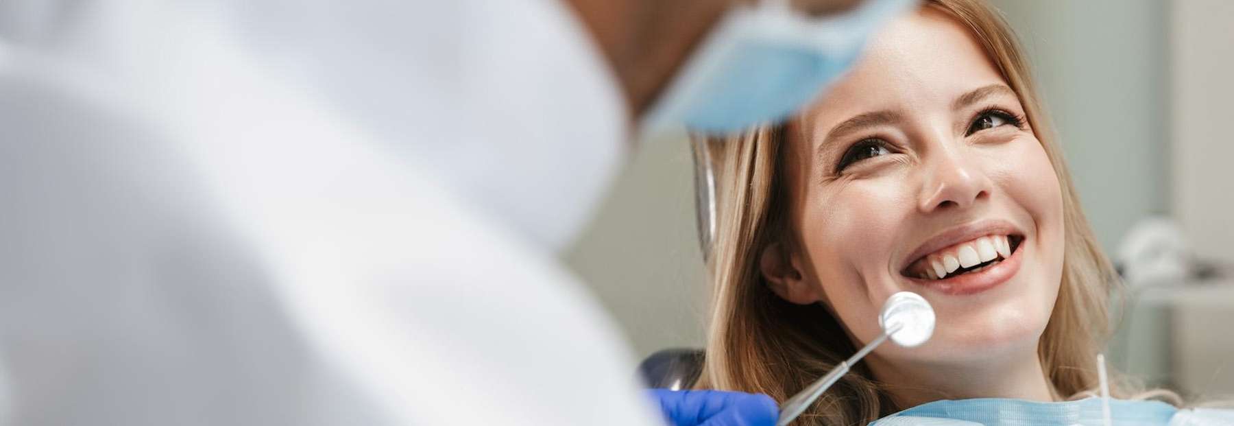Woman in dental chair smiling after wisdom teeth removal, fort collins co